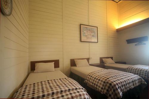 a room with two beds in a room at Hotel Villa Rawa Pening Pratama by Aparian in Bandungan