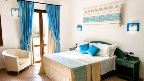 ein Schlafzimmer mit einem Bett, einem Stuhl und einem Fenster in der Unterkunft La Perla Hotel in SantʼAnna Arresi