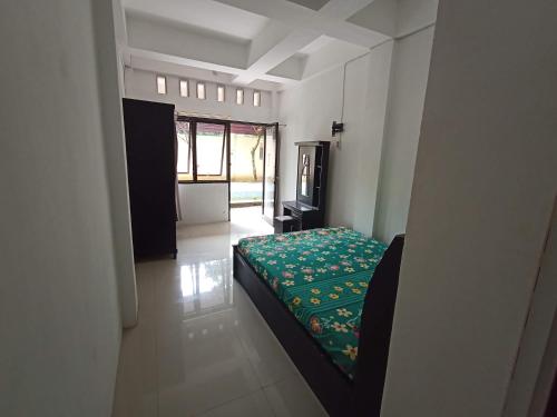 a bedroom with a green bed in a room at Kost Salsabila Cisauk in Kedemangan-wetan