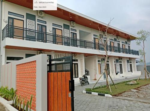 una casa con una puerta naranja delante de ella en De'kost & homestay tegal en Lebaksiu