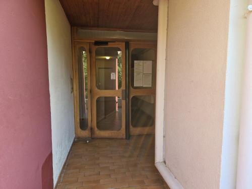 - une entrée pour un bâtiment avec une porte en bois dans l'établissement Appartement Amélie les Bains au pied des THERMES, à Amélie-les-Bains-Palalda
