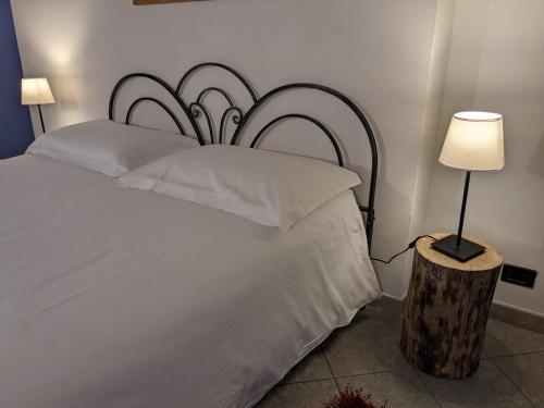 a bedroom with a large white bed with a lamp at New Casa Arcobaleno apartments-Room holiday home in Diano dʼAlba