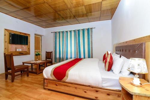 a bedroom with a large bed with a desk and a table sidx sidx at Hotel Onpo Hunder Nubra Valley in Hundar
