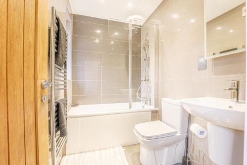 a bathroom with a toilet and a bath tub and a sink at Stylish & Central Homes in Bromley in Bromley