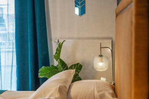 a bedroom with a bed with a lamp and a plant at Honey - confort, proche lac avec garage in Annecy