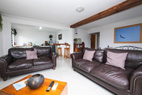 a living room with two leather couches and a table at The Puffin's Nest in Hilton