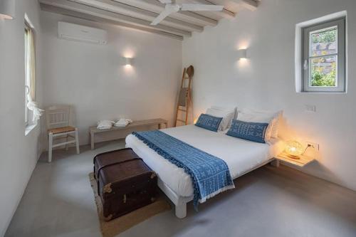 1 dormitorio blanco con 1 cama y 1 maleta en Infinity Villa, luxury house with stunning view in Serifos, en Rámos