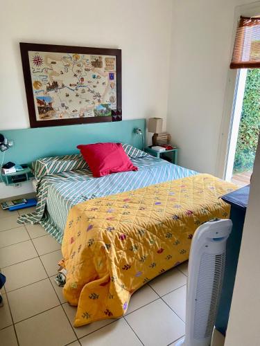 - une chambre avec un lit et un oreiller rouge dans l'établissement Près des claires, au Château-dʼOléron