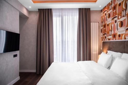 a bedroom with a white bed with a large window at Crystal Hotel in Belgrade
