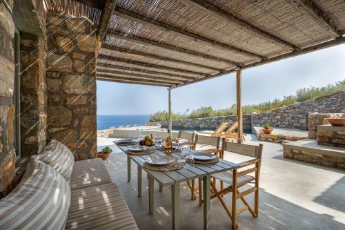 comedor con mesa y vistas al océano en Infinity Villa, luxury house with stunning view in Serifos, en Rámos