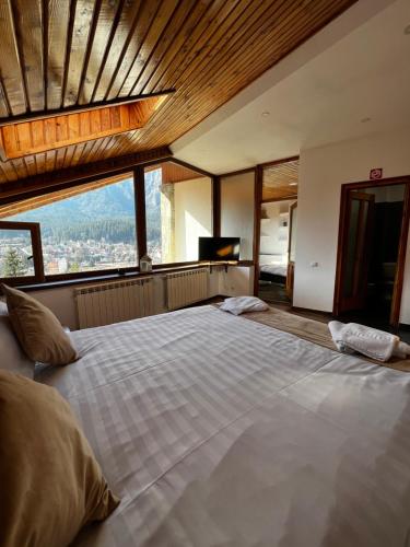 a large bed in a room with a large window at Infinity Villa in Buşteni