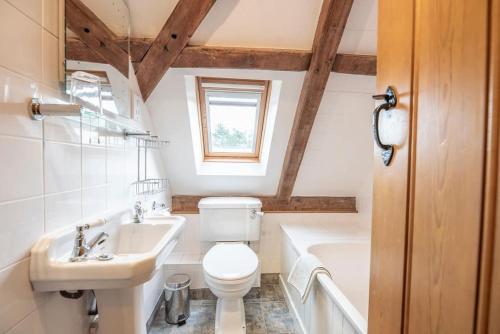 a bathroom with a toilet and a sink and a tub at South Barn, Nr Southwold in Southwold
