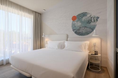 a bedroom with a white bed and a large window at Occidental Ljubljana in Ljubljana