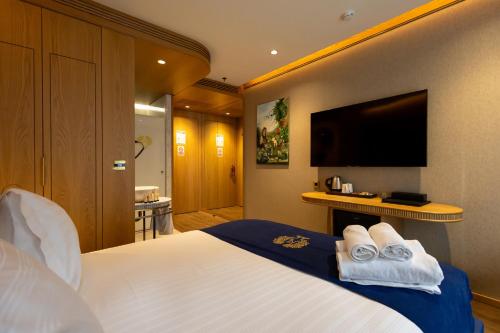 a hotel room with a bed and a flat screen tv at Kate Hotel Special Class & SPA in Istanbul