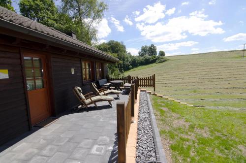 a porch of a house with benches next to a field at Das Ferienhaus Mondschein im Land der tausend Berge - Erholung Pur in idyllischer Alleinlage in Lennestadt