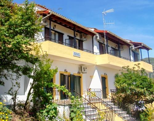 un gran edificio blanco con escaleras y árboles en Aggeliki apartments Dassia By Hotelius en Kato Korakiana