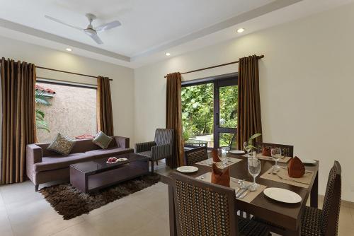 a living room with a dining table and a couch at The Riverview Retreat Corbett by Leisure Hotels in Garjia