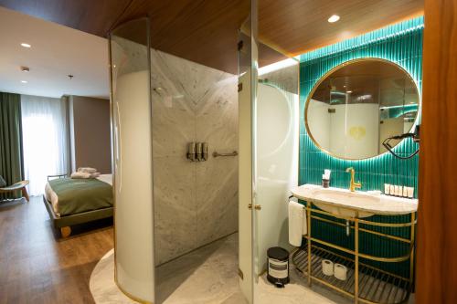 a bathroom with a shower and a sink and a mirror at Kate Hotel Special Class & SPA in Istanbul