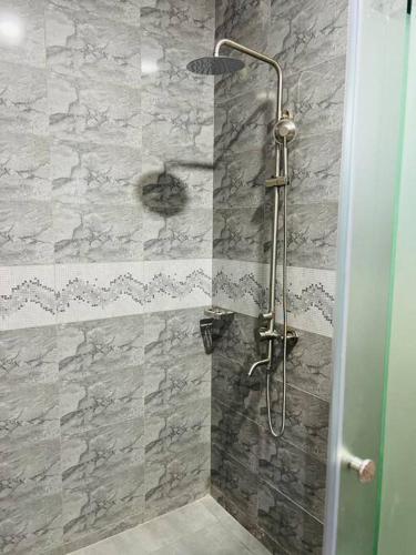 a shower in a bathroom with a stone wall at Crown Elegance Suites in Kampala
