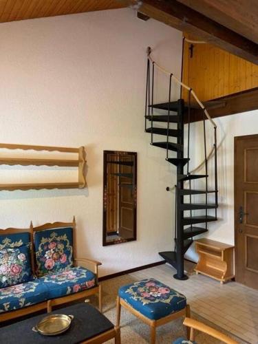 a living room with a spiral staircase and a couch at Résidence A9 - Les Myosotis in Les Mosses