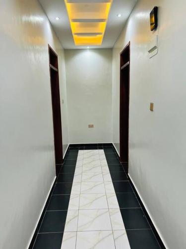 a hallway with a tile floor and a yellow ceiling at Crown Elegance Suites in Kampala