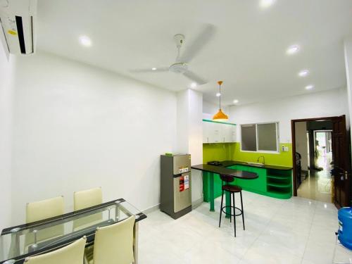 a kitchen with green and white walls and a counter at Happy House in Ho Chi Minh City