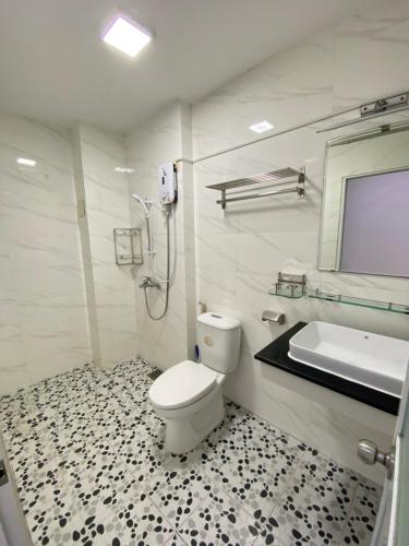 a bathroom with a toilet and a sink and a tub at Happy House in Ho Chi Minh City