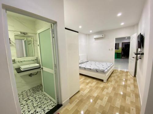 a room with a bed and a bathroom with a mirror at Happy House in Ho Chi Minh City