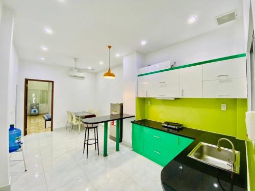 a kitchen with green and white cabinets and a table at Happy House in Ho Chi Minh City