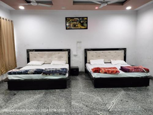 dos camas sentadas una al lado de la otra en una habitación en OH TEN SPOON HOTEL, en Samālkha