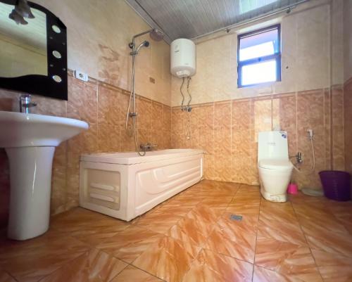 a bathroom with a sink and a tub and a toilet at Mad Vervet Backpackers Hostel in Addis Ababa