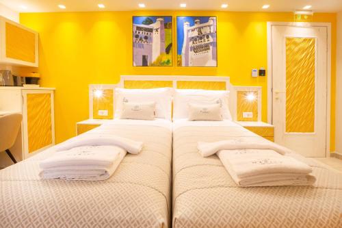 a bedroom with two beds with yellow walls at Mariet Athens Boutique Spa in Athens