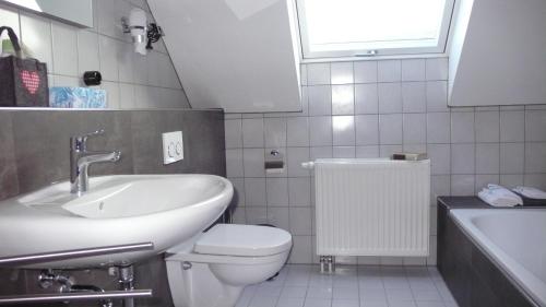 uma casa de banho com um lavatório, um WC e uma janela. em Ferienwohnung Rhönbauer Altengronau em Sinntal