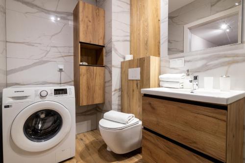 a bathroom with a washing machine and a sink at Apartament z dwoma sypialniami i z miejscem postojowym in Białystok