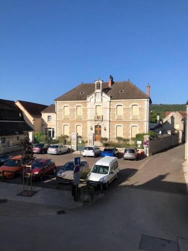 un parking avec des voitures garées devant un bâtiment dans l'établissement logez au cœur de la route des grands crus, à Vougeot