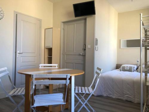 Zimmer mit einem Tisch, Stühlen und einem Bett in der Unterkunft logez au cœur de la route des grands crus in Vougeot