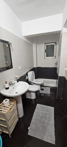 a bathroom with two sinks and a toilet at Library Apartment by Bohem Rentals in Durrës