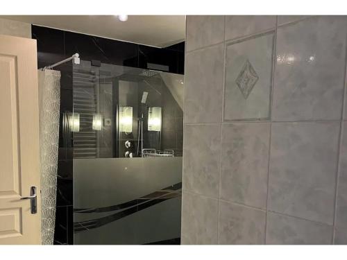 a bathroom with a shower with a tub and a sink at Maison de Famille de 1823 in Chastreix