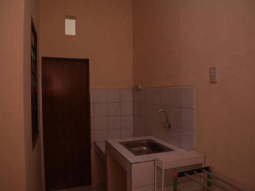 uma pequena cozinha com um lavatório num quarto em Tendy Guest House 