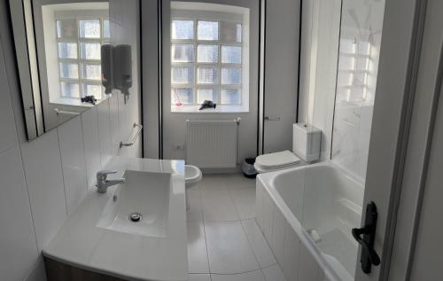 La salle de bains blanche est pourvue d'un lavabo, d'une baignoire et de toilettes. dans l'établissement Viviendas vacacionales as lagas, à Palas de Rei