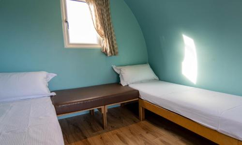 two beds in a room with a window at Broom Leisure Camping Pods in Annan
