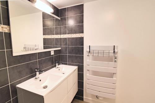 une salle de bain avec un lavabo blanc et un miroir dans l'établissement Le Grenier - Domaine de la Mauselaine, à Gérardmer