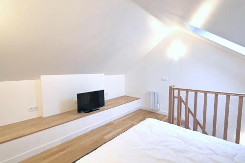 une chambre avec un lit et une télévision sur un mur dans l'établissement Le Grenier - Domaine de la Mauselaine, à Gérardmer