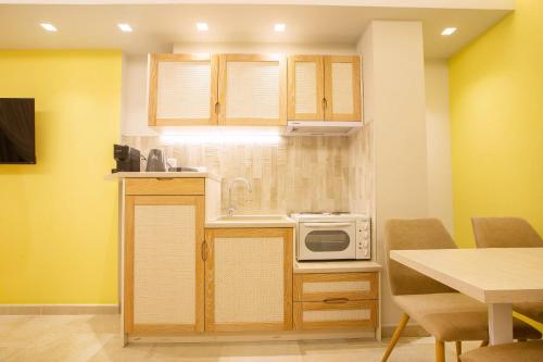 a small kitchen with a microwave and a table at Mariet Athens Boutique Spa in Athens