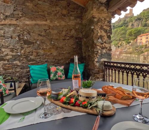 a table with a tray of bread and wine glasses at 4 star CABARET Lastours 4 Châteaux amazing Cathar landmark Private luxury 4 Star air conditioned Terrasse with views in Lastours