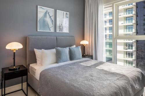 una camera da letto con un letto con due lampade e una finestra di Silkhaus Tower with Private Beach in Exclusive Location a Dubai