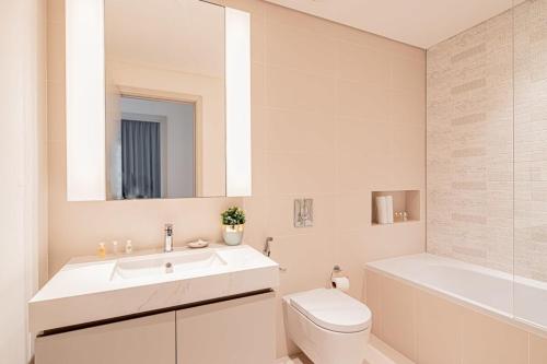 ein Badezimmer mit einem Waschbecken, einem WC und einer Badewanne in der Unterkunft Silkhaus Tower with Private Beach in Exclusive Location in Dubai