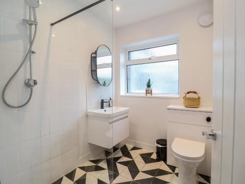 a white bathroom with a sink and a toilet at Herring House in Lowestoft