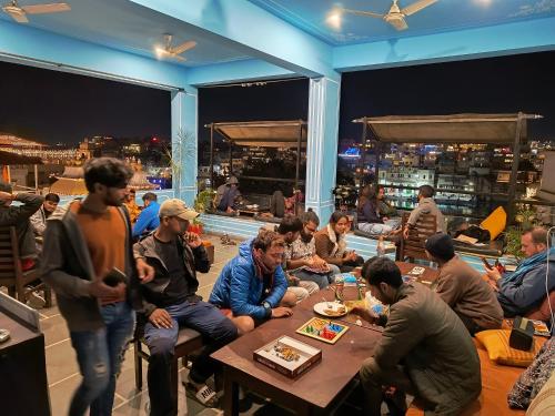 a group of people sitting around a table in a restaurant at Madpackers Udaipur in Udaipur