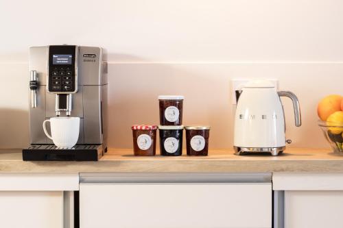 a coffeemaker and cups on a kitchen counter at La Barule in Charols